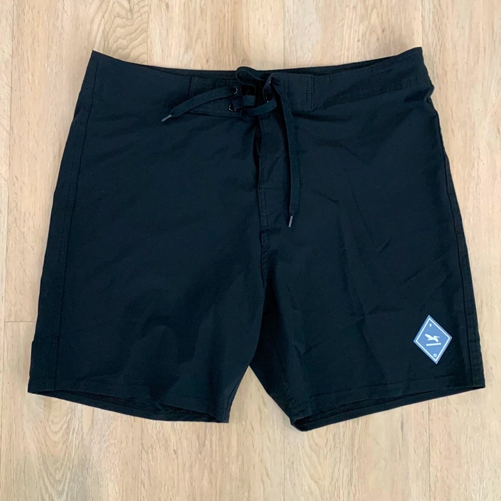 Fragile Ocean black board shorts with blue wave pocket